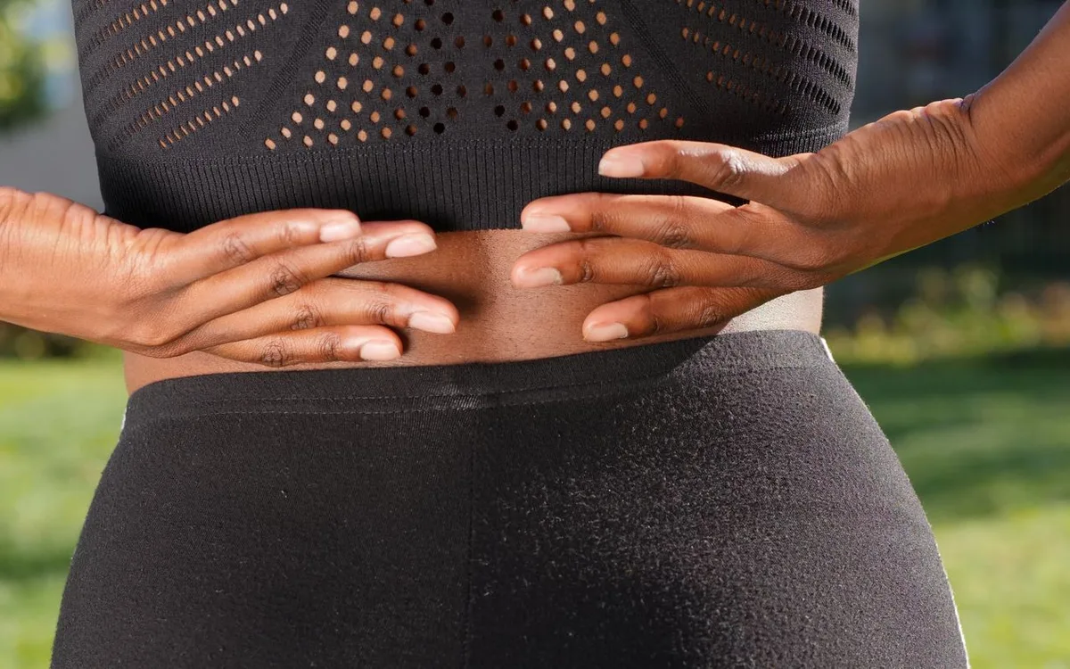 Woman touching her lower back