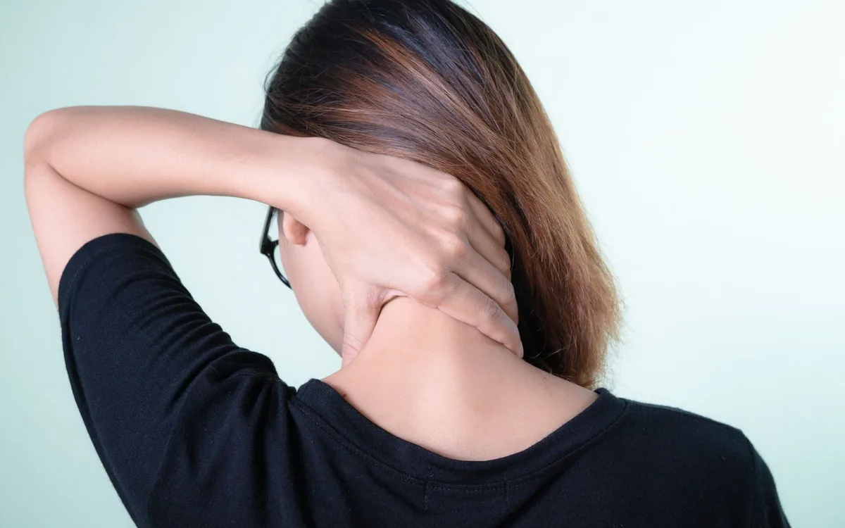 Woman resting a hand on the back of her neck