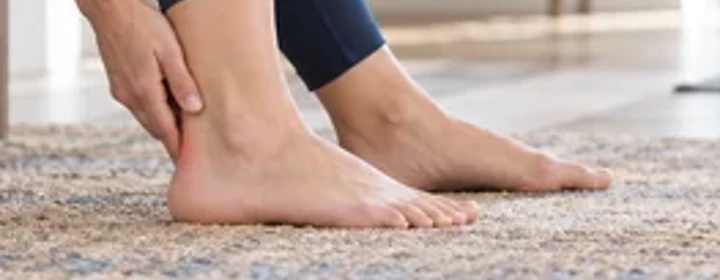 Woman holding her painful heel