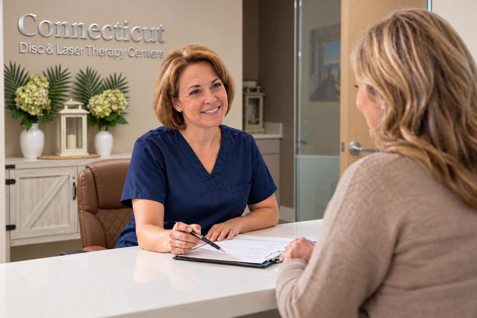 Sue helping a patient with paperwork in our reception office
